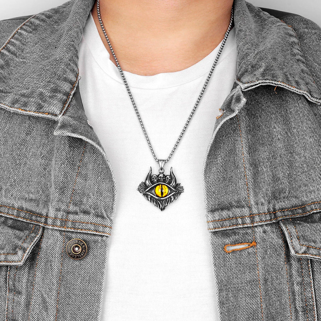 Silverfärgat halsband föreställande tre små dödskallar och ett gult djävulsöga med demonhorn
