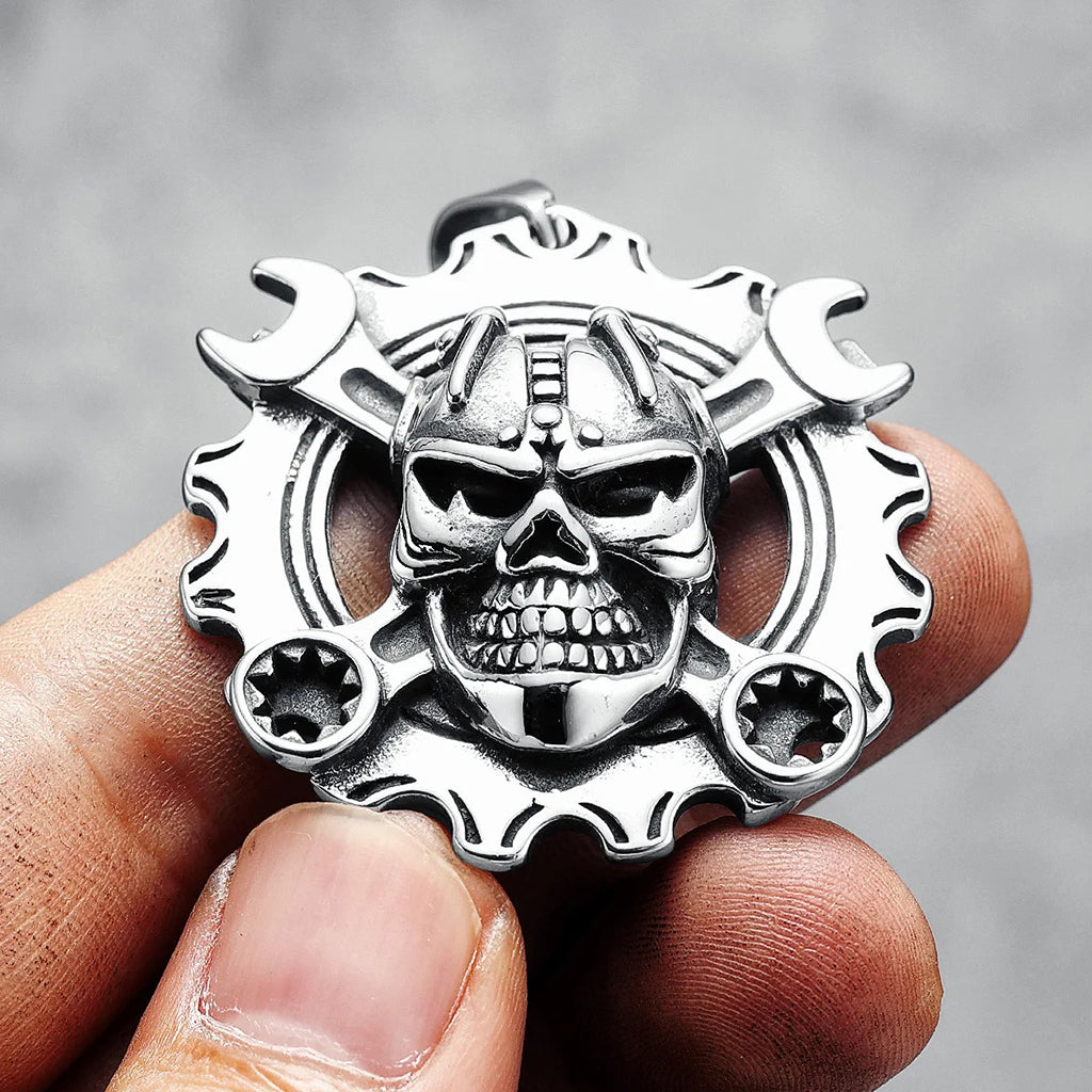 Silverfärgat hängsmycke föreställande ett kugghjul med en döskalle med korslagda skiftnycklar