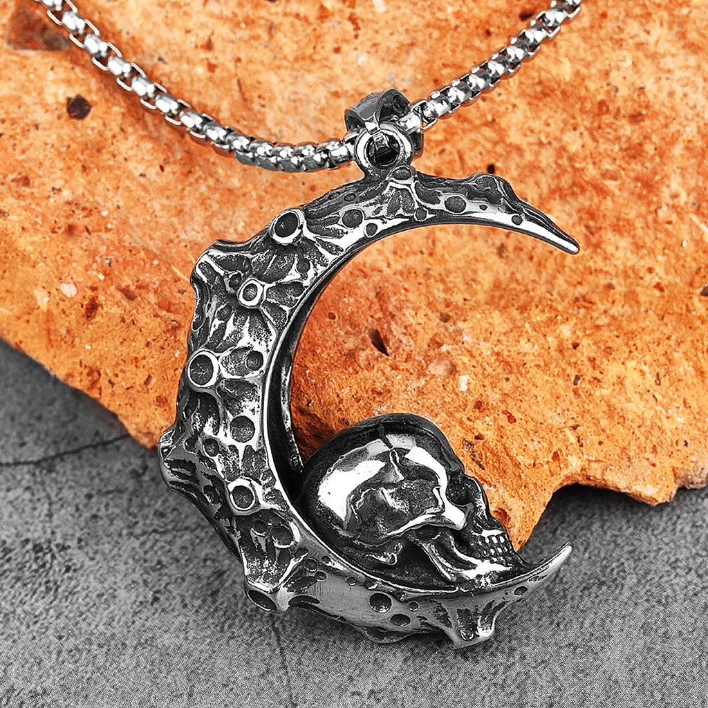 Silverfärgat hängsmycke föreställande en måne med en mänsklig dödskalle