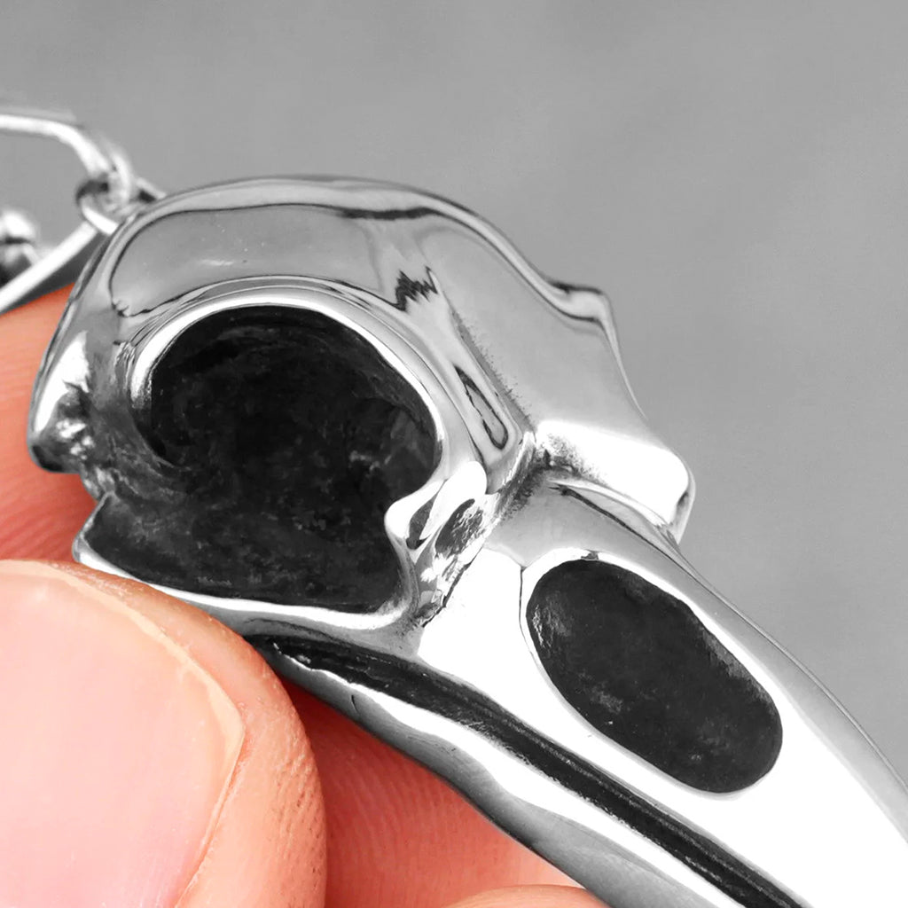 Silverfärgat hängsmycke föreställande döskallen från en kråka