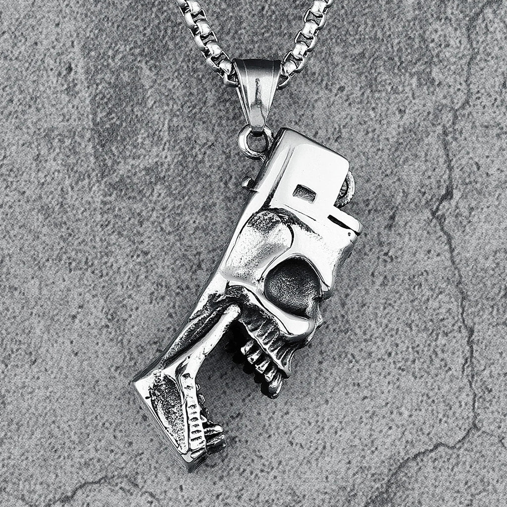 Silverfärgat smycke föreställande en dödskalle formad som en klassisk tändare. Dödskallens tänder fungerar som en flasköppnare