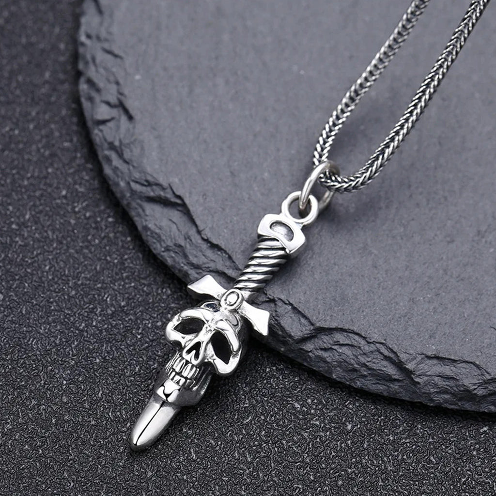 Silverfärgat sterling silver halsband föreställande ett svärd med en dödskalle på klingan
