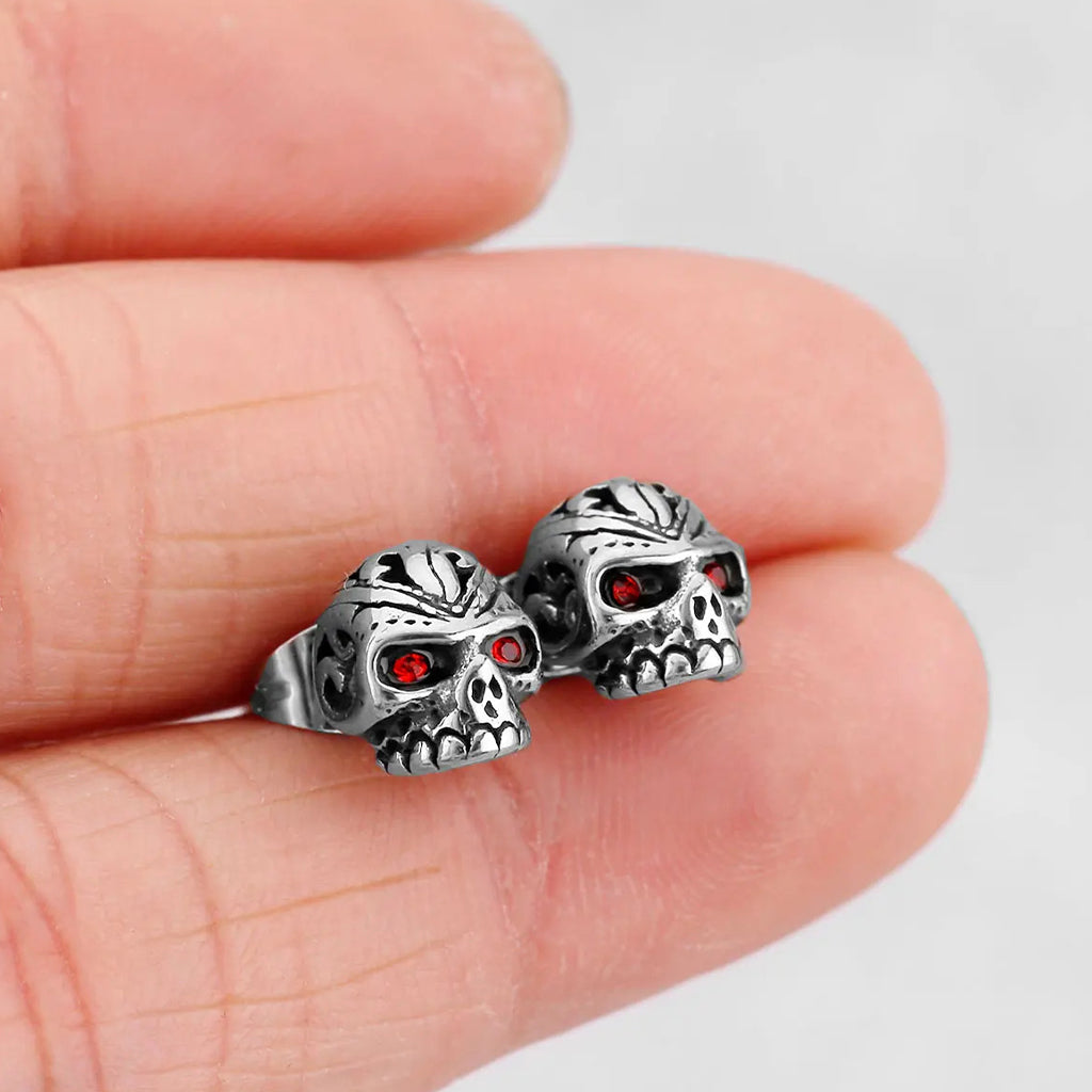 Stiftörhänge som föreställer en dödskalle med ornament och röda zirkoner som ögon