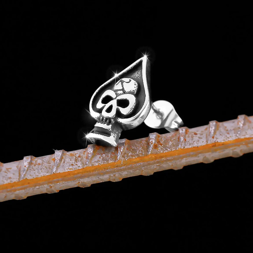 Silverfärgade stiftörhängen formade som spader ess med en dödskalle i mitten