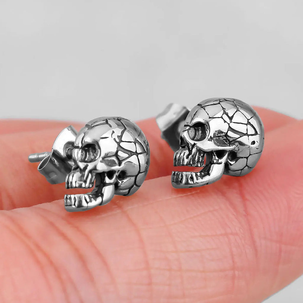 Silverfärgade stiftörhängen föreställande dödskallar med sprickor på kranium