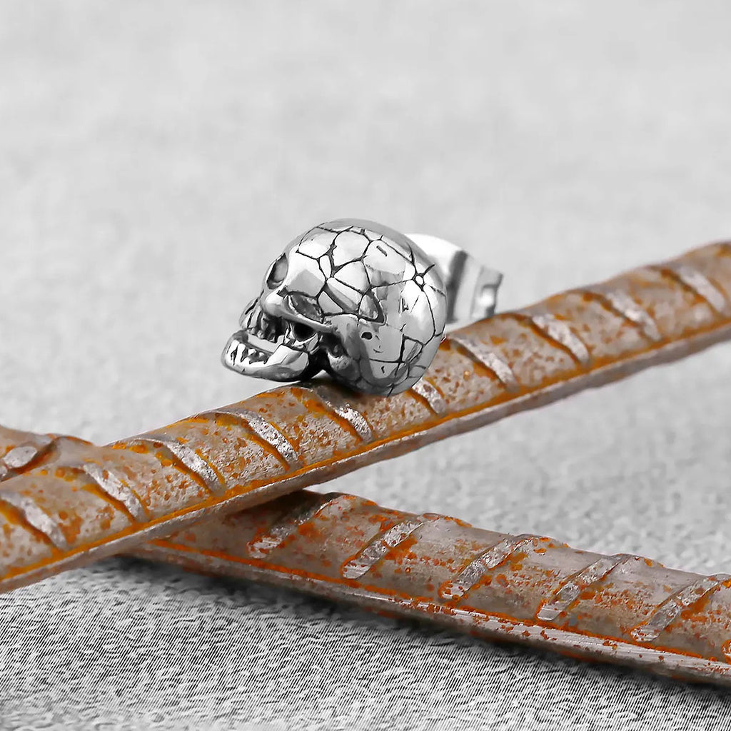 Silverfärgade studs föreställande spruckna dödskallar