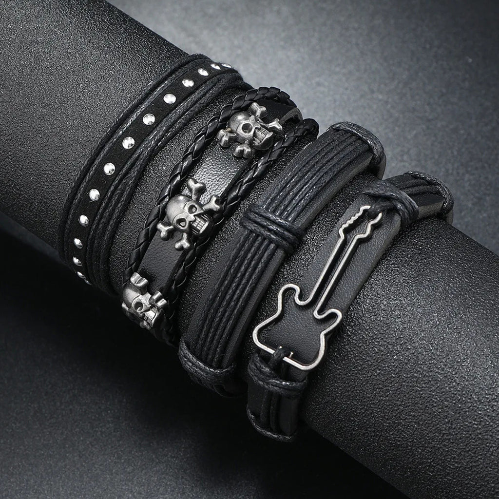 Svartfärgade läderarmband med nitar föreställande skallar och en elgitarr