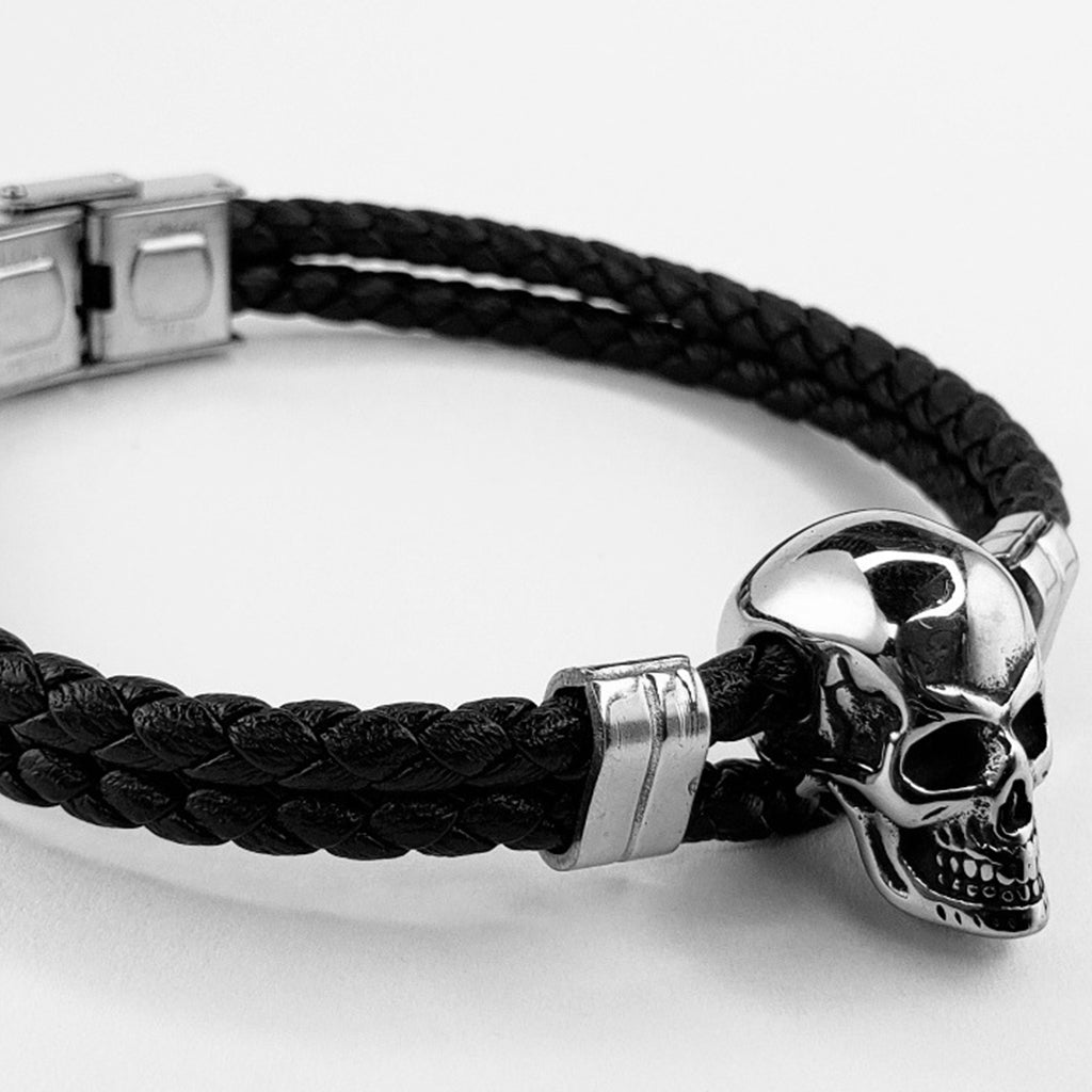 Boloflätat svartfärgat läderarmband med en silverfärgad skalle