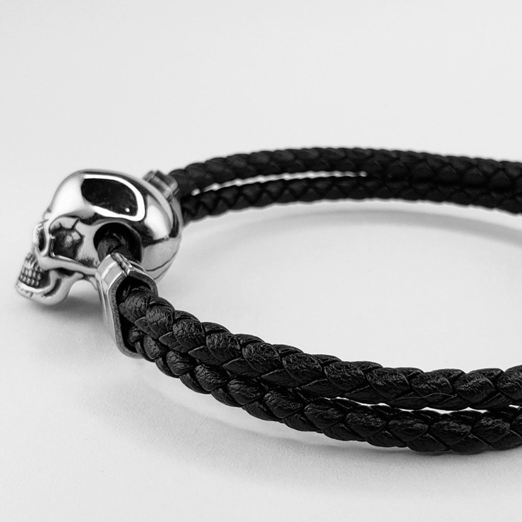 Boloflätat svart läderarmband med en silverfärgad skalle