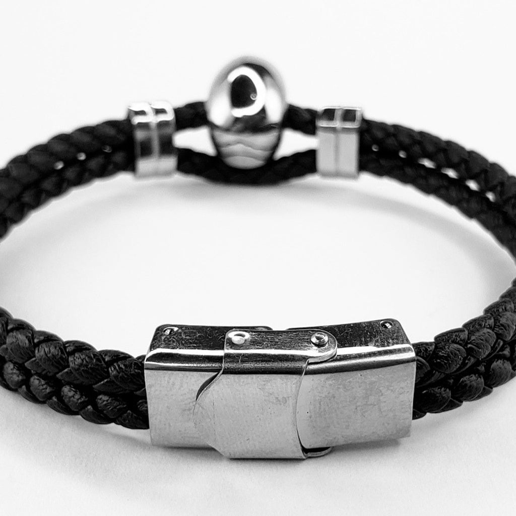 Boloflätat svart läderarmband med en silverfärgad dödskalle i stål