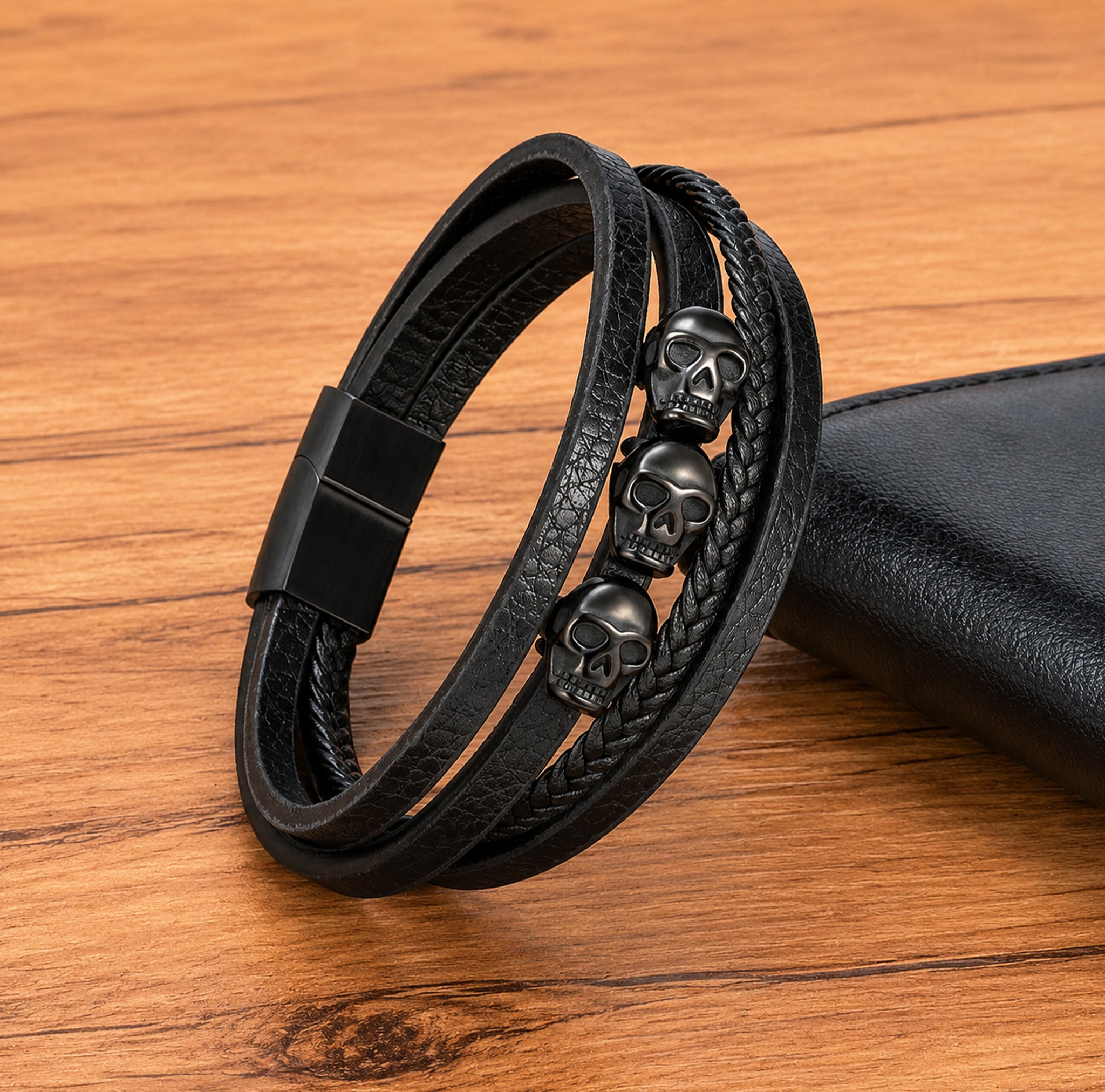 Svart dödskalle-armband av läder med tre dekorativa dödskallar, tillverkade av svartfärgat rostfritt stål