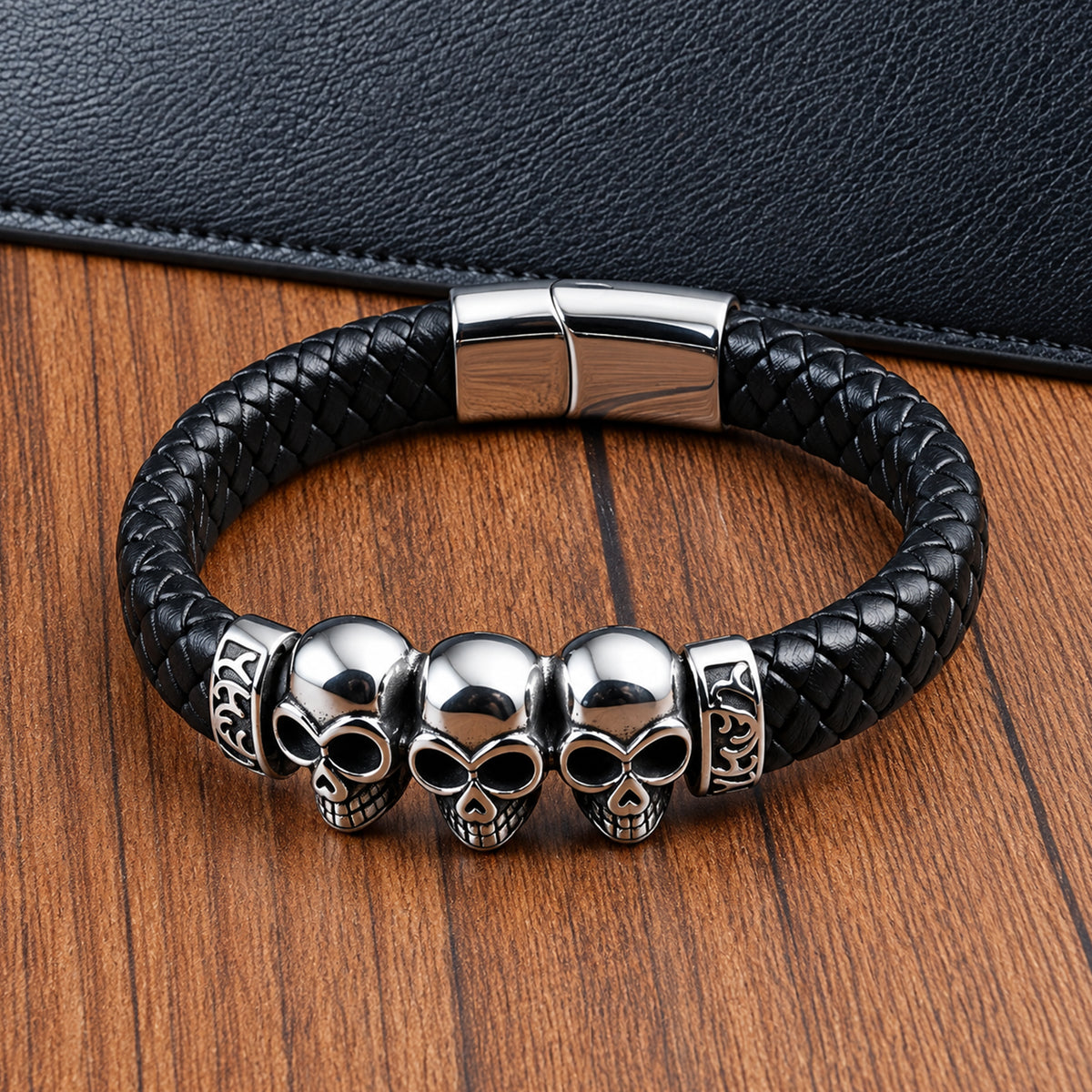 Svart flätat armband med tre silverfärgade dödskallar