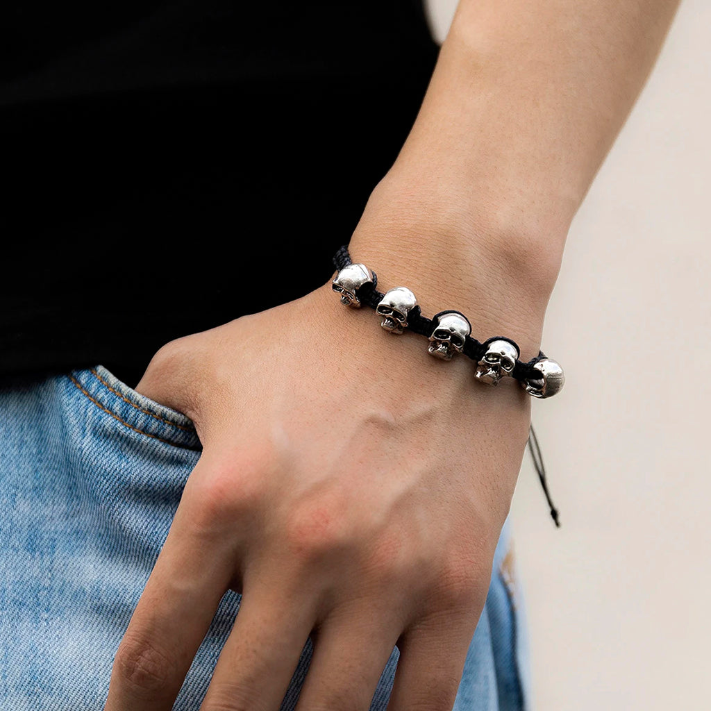 Mörkt flätat reparmband med silverfärgade kranium