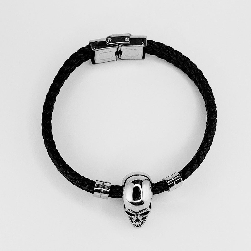 Boloflätat svart läderarmband med en silverfärgad döskalle