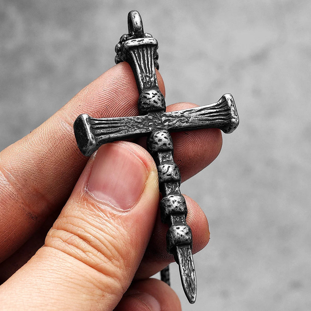 Mörkt kors smycke med dödskallar och texten "Deathly" graverad på korsarmarna