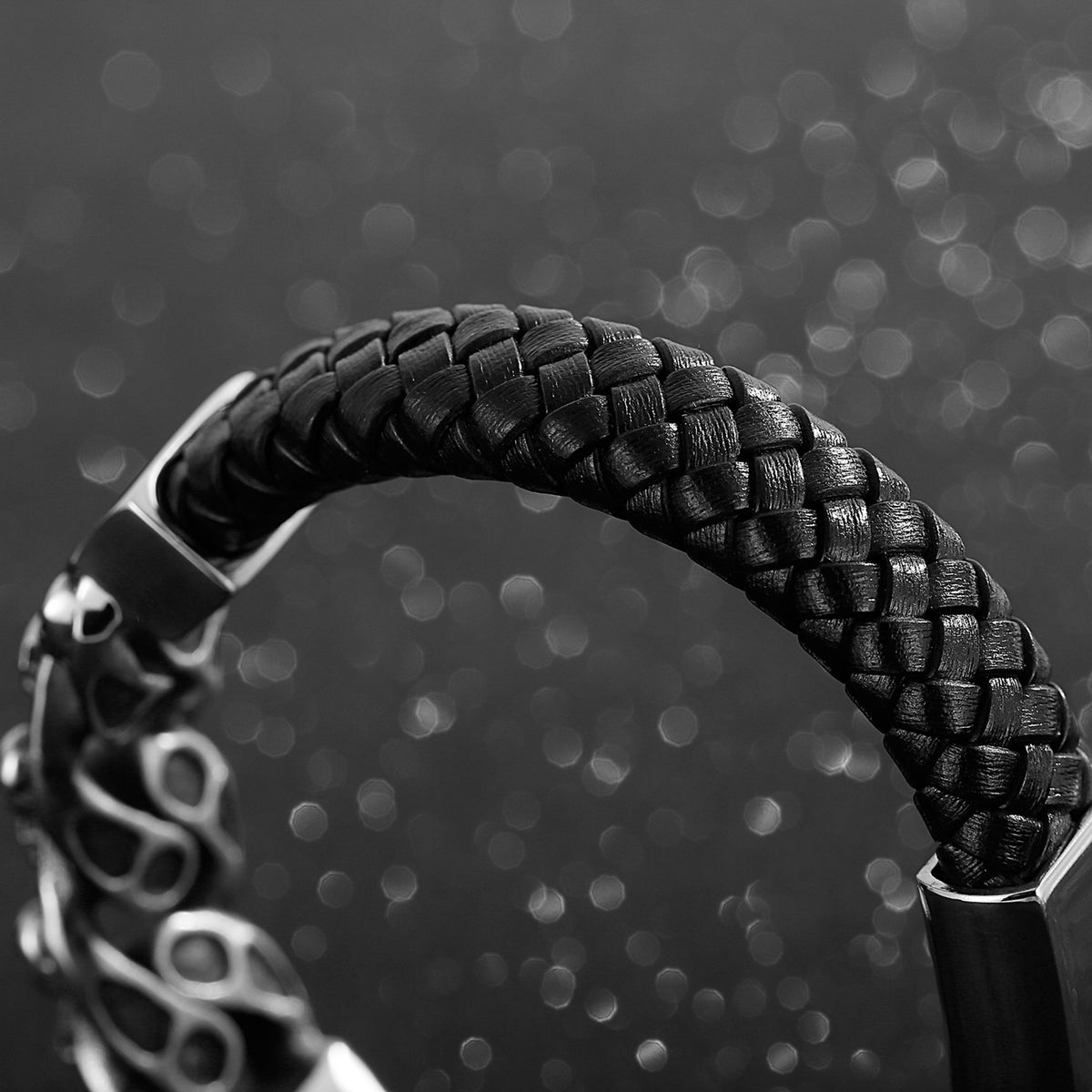 Svart läderarmband med dekorativt stålsmycke med flera små dödskallar
