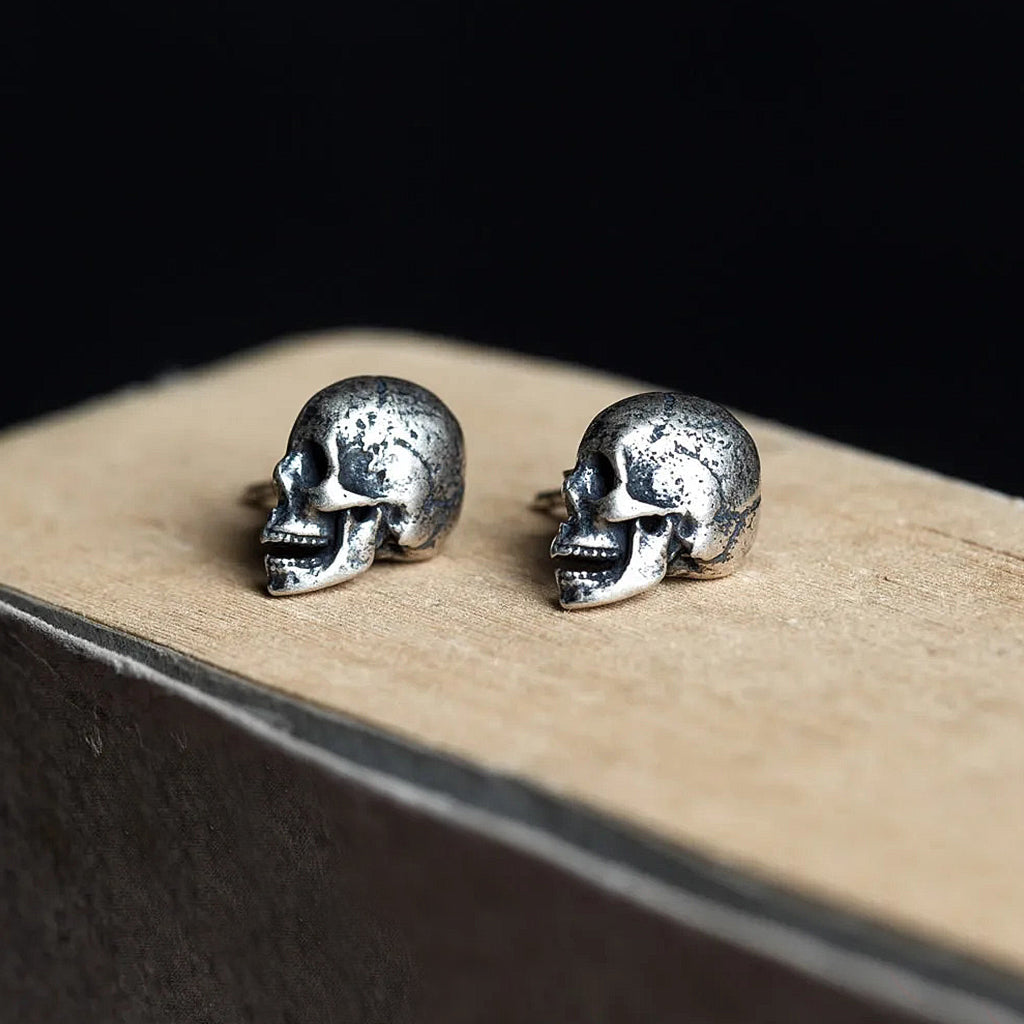 Silverfärgade ear studs-örhängen av sterlingsilver som föreställer dödskallar i profil