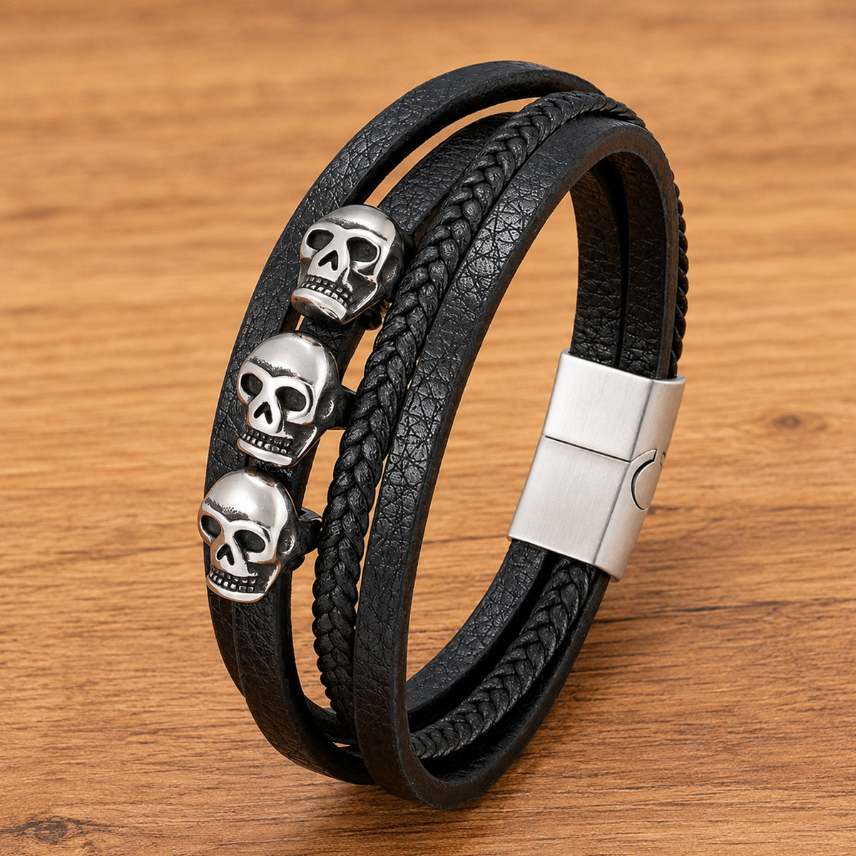 Flerskiktat svart läderarmband med tre silverfärgade dödskallar och rebellisk smyckesdesign