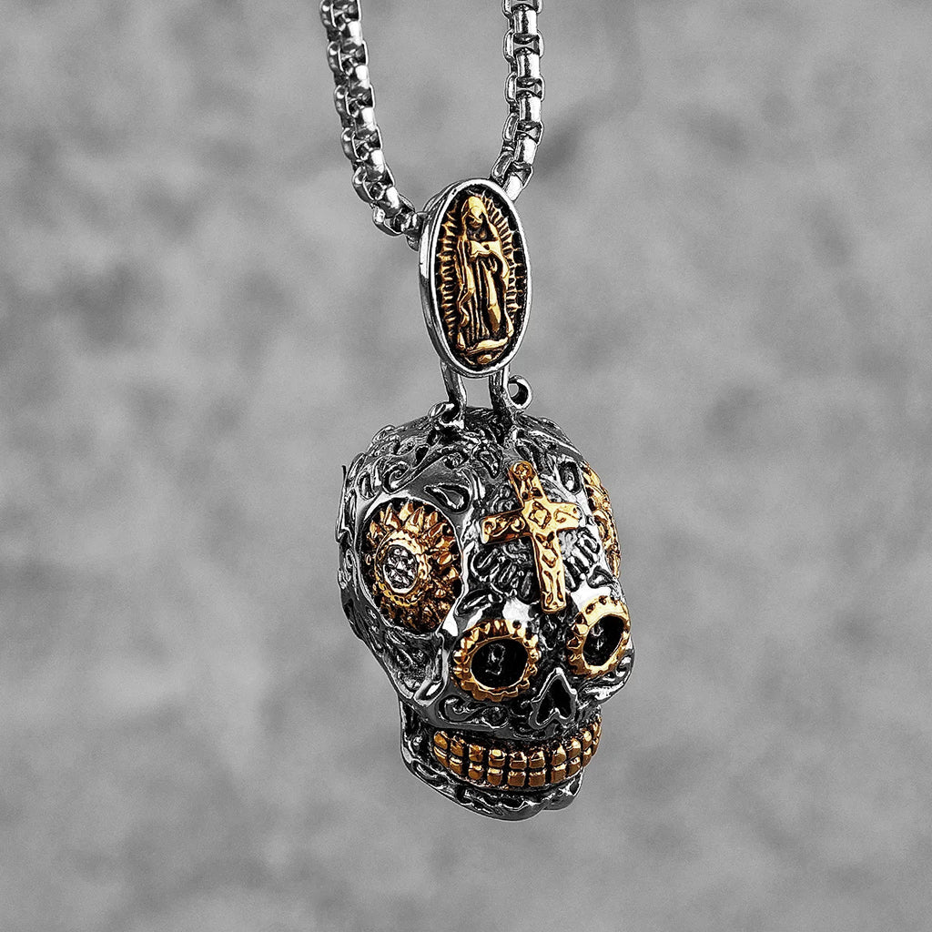 Silverfärgat hängsmycke föreställande en mexikansk calavera dödskalle med guldfärgade detaljer