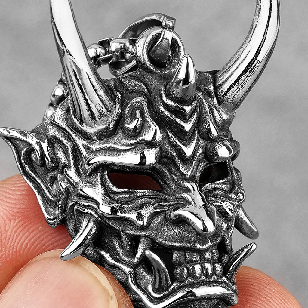 Silverfärgat smycke föreställande en japansk Hannya mask