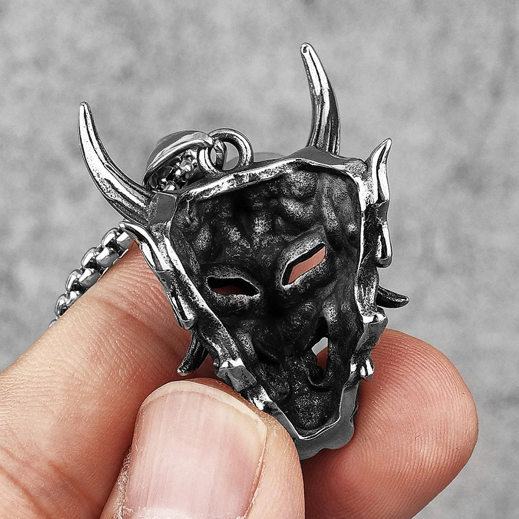 Silverfärgat hänge föreställande en demonisk Hannya mask