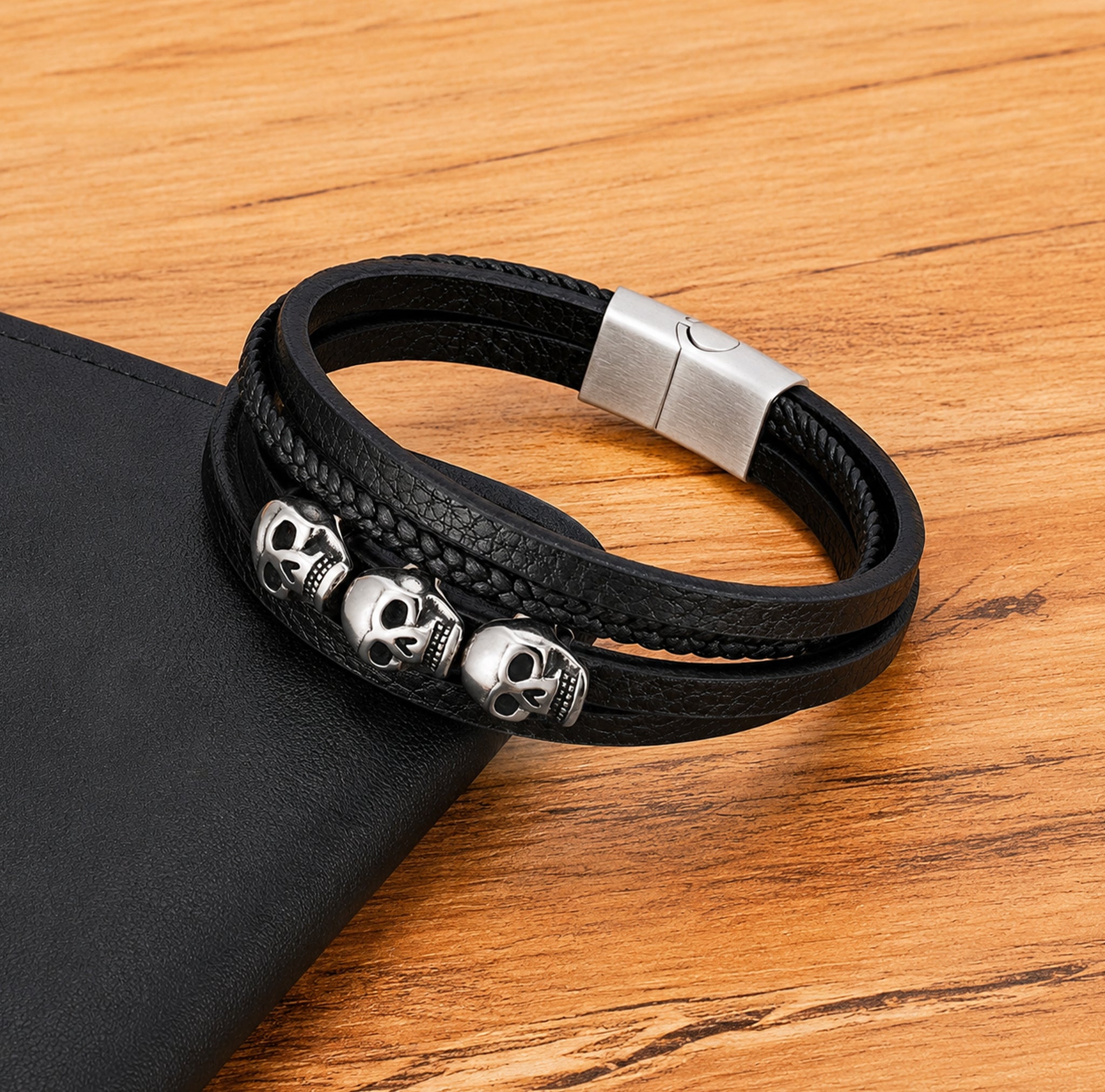 Svart läderarmband av äkta läder med flerremdesign och tre silverfärgade dödskallar av rostfritt stål