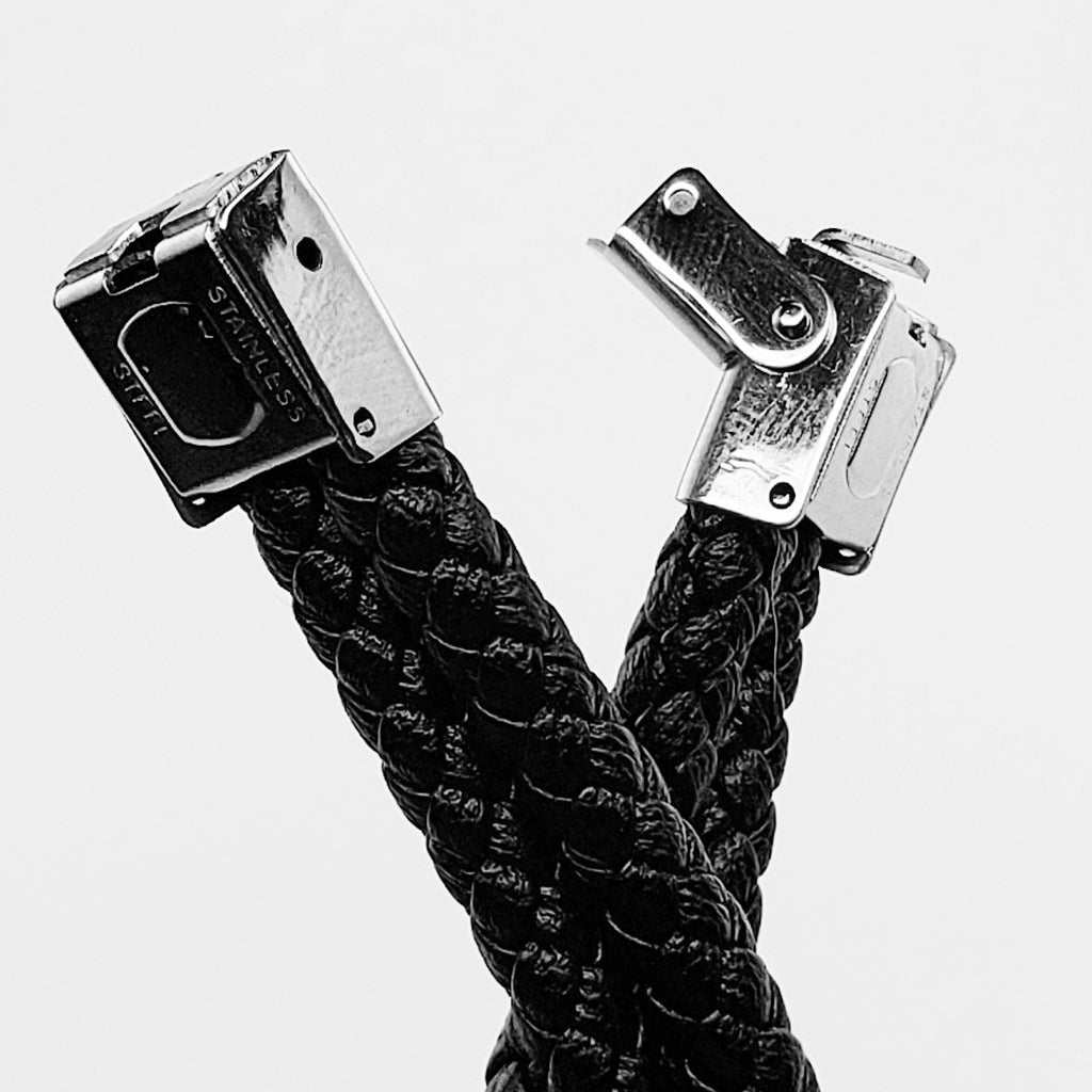 Boloflätat svart läderarmband med en silverfärgad döskalle