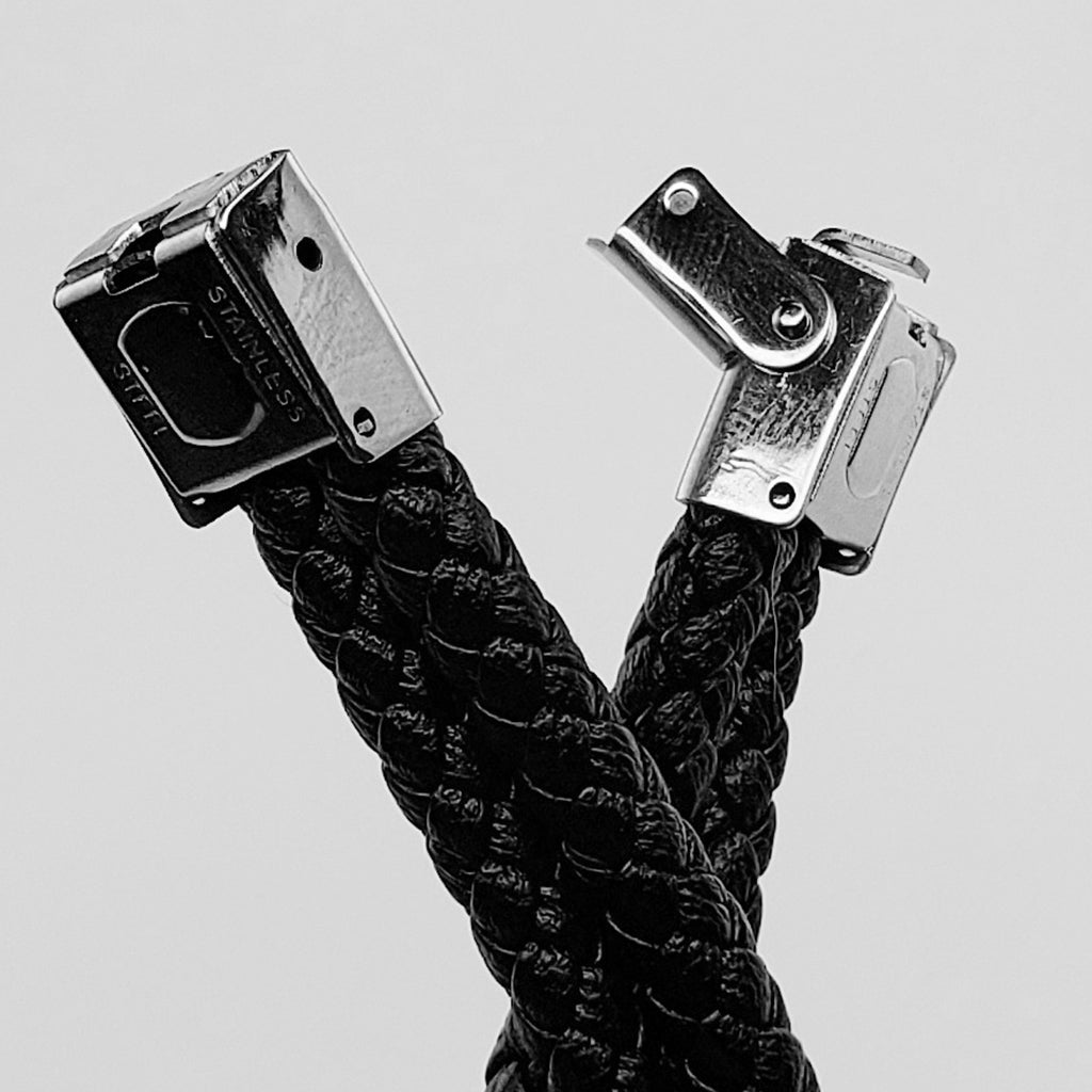 Svartfärgat armband i flätat läder med två silverfärgade dödskallar i rostfritt stål