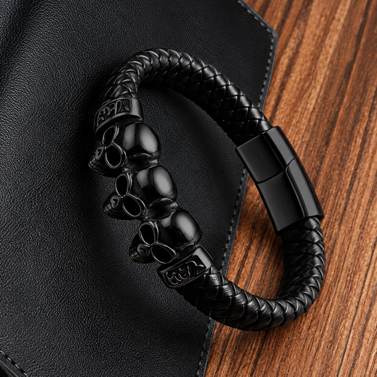 Svart armband av vävt läder med tre svarta dödskallar framtill
